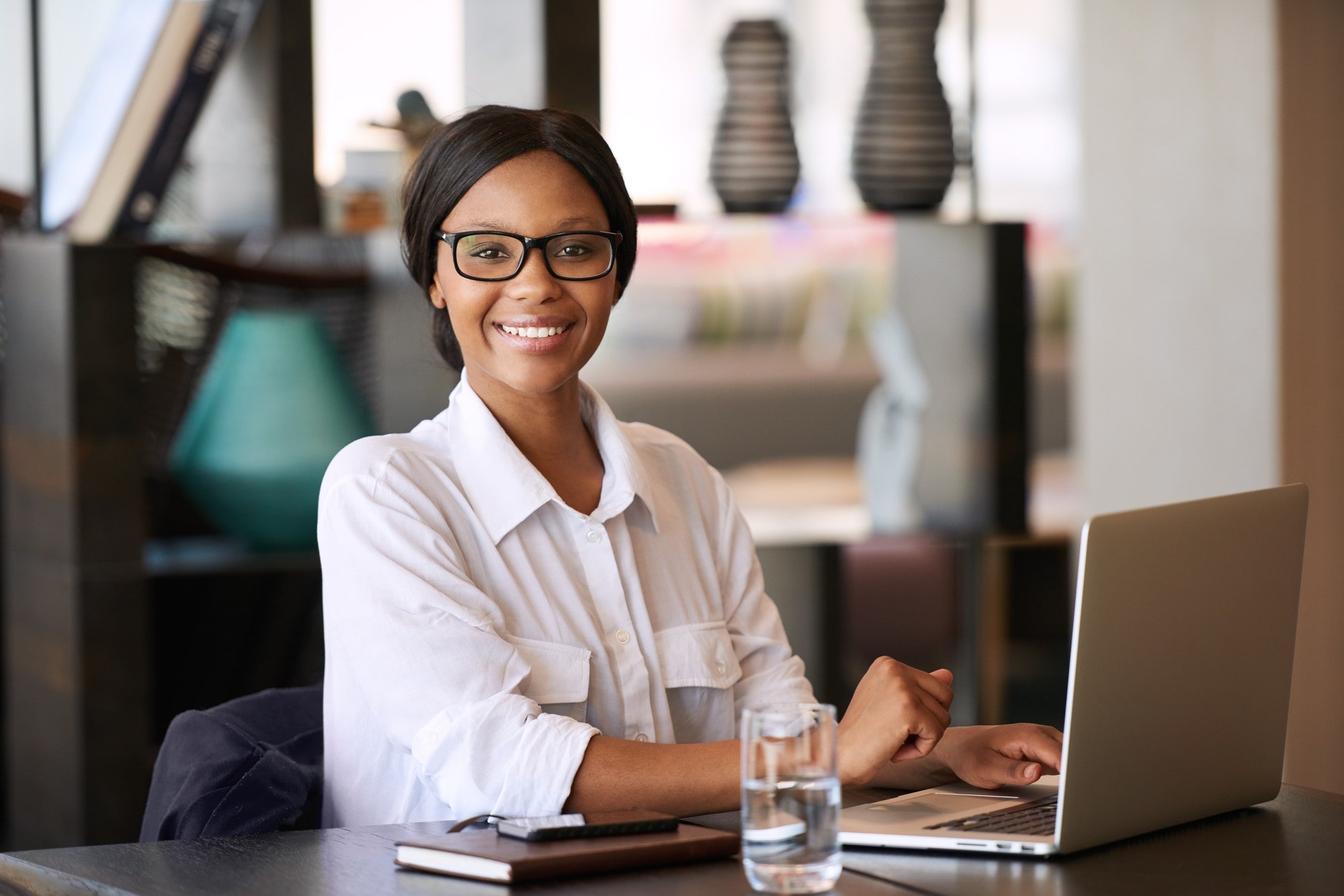 Smiling Woman Seated Behind Her Personal Computer